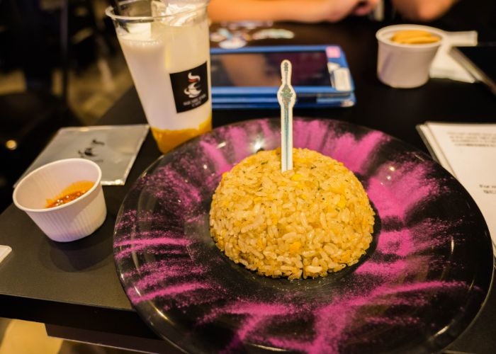 A serving at fried rice at the Final Fantasy cafe, with a sword sticking out of the middle.